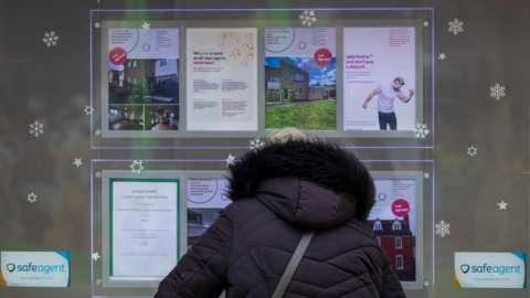 Woman looks in estate agent's window