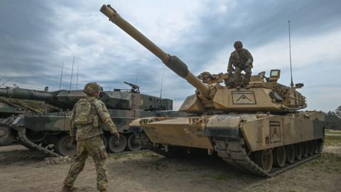 MAY 06, 2023: American soldiers are seen next to M1A2 Abrams tank during a high-intensity training session at the Nowa Deba training ground on May 06, 2023 in Nowa Deba, Poland. Anakonda-23 is the highlight of the Polish Army's training calendar this year.