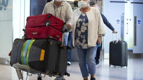 Passengers from the Holland America Line ship Zaandam walk through arrivals in Terminal 2 at Heathrow Airport in London, after flying back on a repatriation flight from Florida.