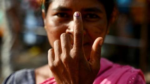 A woman shows her inked finger after casting her ballot to vote at a polling station as voting starts in the first phase of India's general election at the Dugeli village of Dantewada district, in the country's Chhattisgarh state on April 19, 2024.