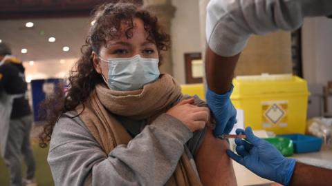A woman receives the AstraZeneca Covid19 vaccine at an NHS vaccination centre in Ealing, west London, Britain 12 February, 2021. UK is close to completing first step of the vaccination programme, with 13.5m people having had a first jab according to NHS England.
