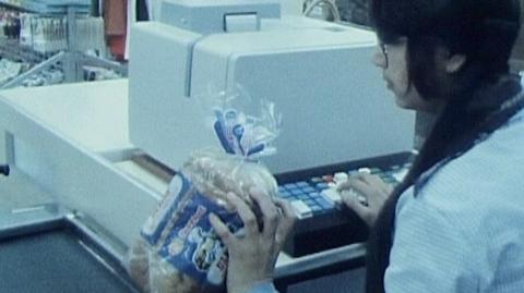 A checkout worker at a till in a supermarket in 1978.