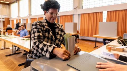 A woman casts her ballot for the state elections in Hesse (Hessen) at a polling station in Ginsheim-Gustavsburg, central Germany