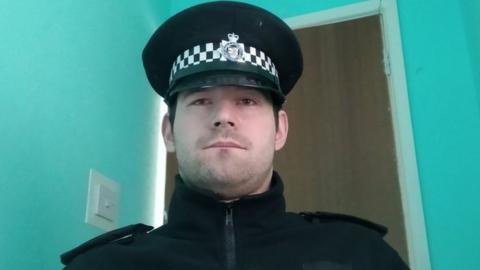 A man wearing a police-style uniform