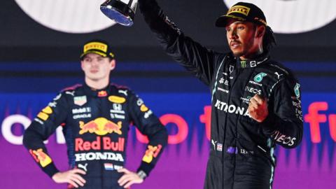Max Verstappen (left) looks on as Lewis Hamilton (right) celebrates on the podium after winning the Saudi Arabia Grand Prix