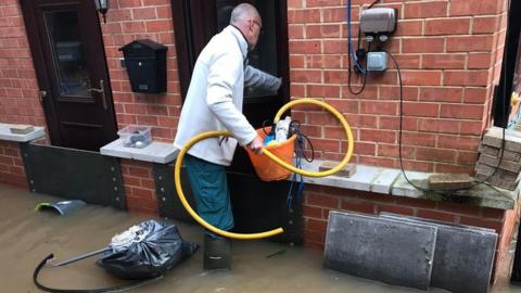 Derek Lown trying to salvage his house after the latest flooding in January