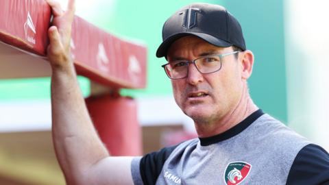 Leicester Tigers head coach Dan McKellar leans on the dugout