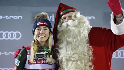 Mikaela Shiffrin on the podium with Father Christmas