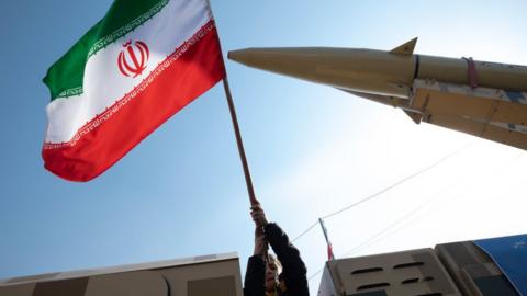 A man waves an Iran flag