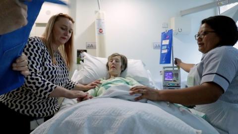 A doctor and a nurse attend to a cancer patient