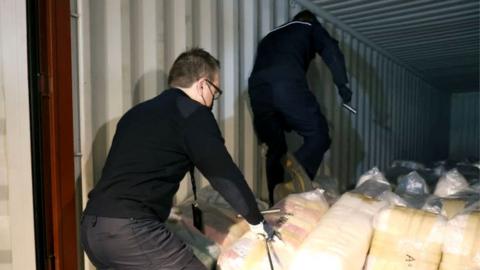 Belgian customs officers search for drugs in a container at Antwerp's port, on January 7, 2022.