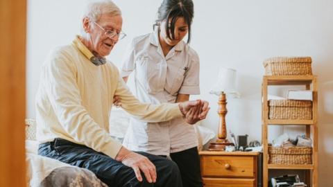 Carer helping man