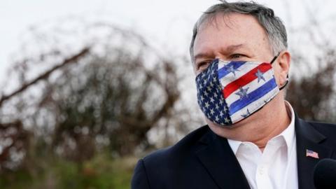 Mike Pompeo wearing a face mask with a US flag on it, standing in the occupied Golan Heights