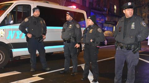 Police officers stand guard on a road after a 19-year-old assailant attacked three NYPD officers with a machete near Times Square during the new year celebrations in New York, United States on December 31, 2022.