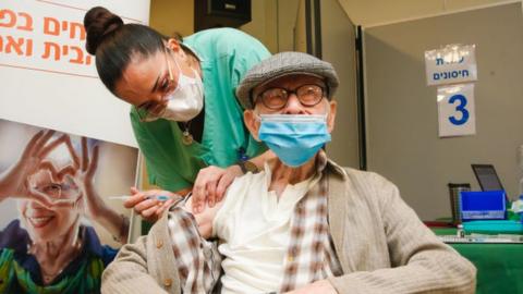 An elderly man being vaccinated