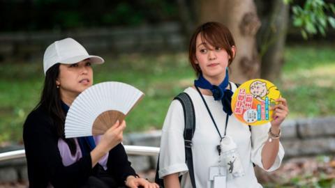 People in Tokyo fan themselves