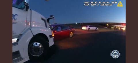 A white lorry that has crashed into a red car, a still from a body cam video