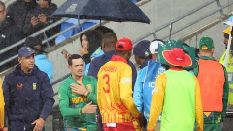 South Africa and Zimbabwe shake hands after their abandoned ICC Men's T20 World Cup
