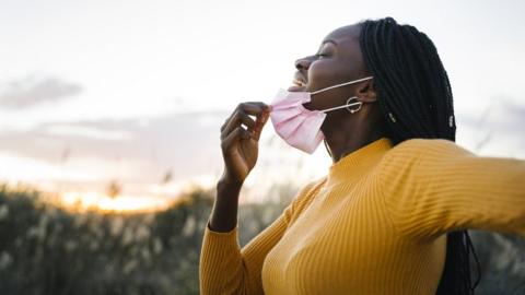 Woman removes face mask