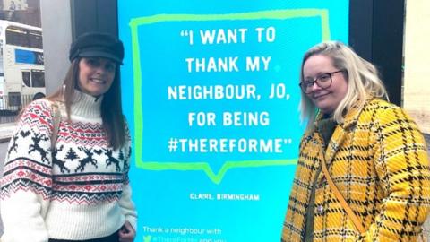 Jo Stretch and Claire Johnson next to the billboard