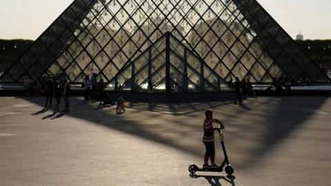 A person rides an e-scooter in Paris, France