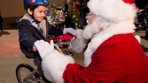 Boy on bike with Santa Claus