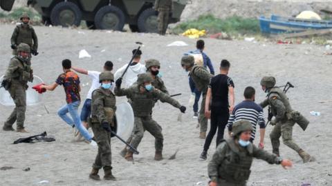 A Spanish legionnaire hits a Moroccan citizen at El Tarajal beach, near the fence between the Spanish-Moroccan border