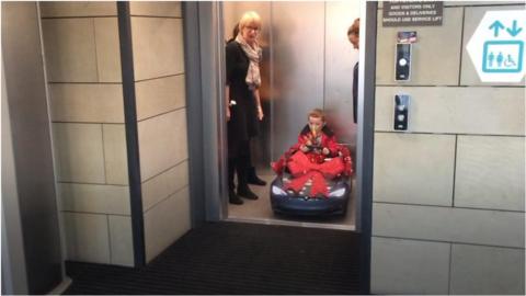 One of the young patients drives the electric car