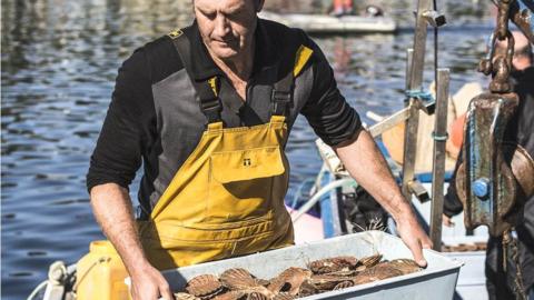 Man carrying box of shellfish