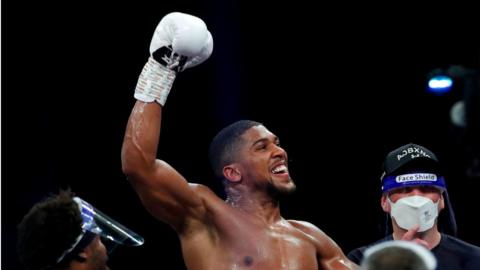 Anthony Joshua celebrates a win in the boxing ring