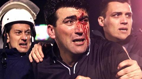 Greek police rush bloodied referee Makis Efthymiadis out of the stadium after a March 2002 match between Panathinaikos and Olympiakos marred by post-game violence