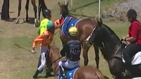 A video still of jockey Dylan Caboche about to hit a horse prior to a race