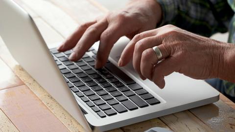 Hands typing on a laptop keyboard