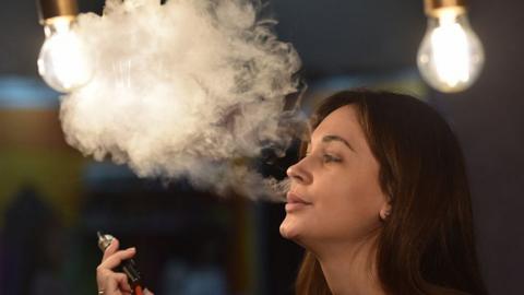 Woman vaping in outdoor setting