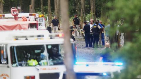 Authorities work the scene of a plane crash at a park along Robert Cardinal Airport Road across from the Tuscaloosa Regional Airport in Northport, Ala., Sunday, Aug. 14, 2016