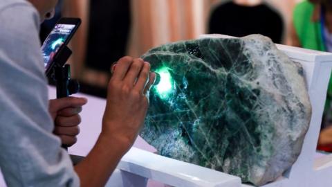 Jade vendor inspects large chunk of Jade in Myanmar