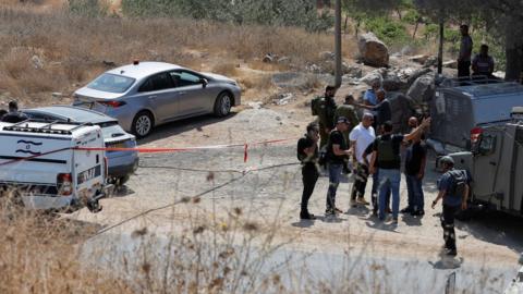 Israeli security forces inspect the scene of a deadly shooting attack south of Hebron, in the occupied West Bank (21 August 2023)