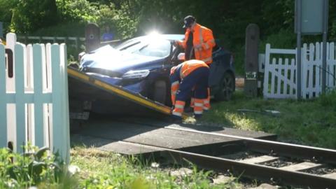 Damaged car at railway level crossing