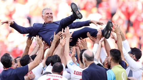 Iran coach Carlos Queiroz is thrown up in the air by his players to celebrate their 2-0 win over Wales in the 2022 Fifa World Cup