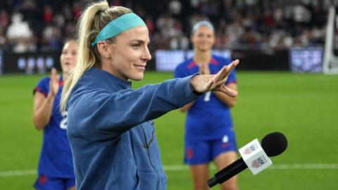 Julie Ertz drops the mic after speaking to the crowd at the end of her final match