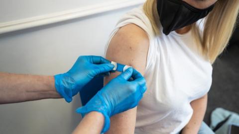 A plaster is applied to an arm after a vaccine
