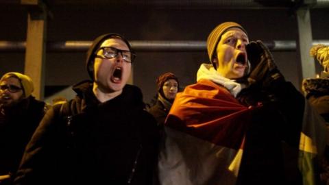 Two protesters shout during a demonstration against the labour law changes in Budapest on December 17, 2018.