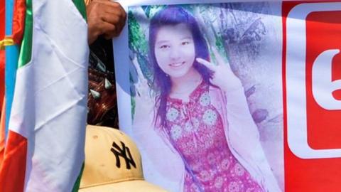 A protester holds up banner with an image of a female anti-coup demostrator, Mya Thwe Thwe Khine