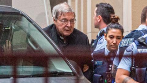 Police lead George Pell from a prison van into the court on Thursday