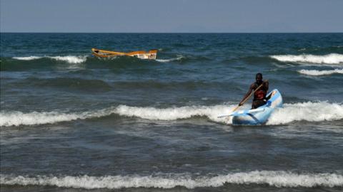 A man leads his traditional boat to shore, at the Saga on Lake Malawi, on July 17, 2011