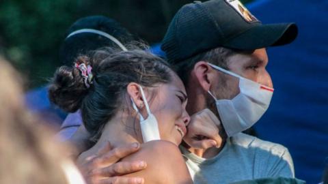 Relatives of one of the miners cry as rescue teams carry the body of a miner in El Zulia, Norte de Santander department on 4 June