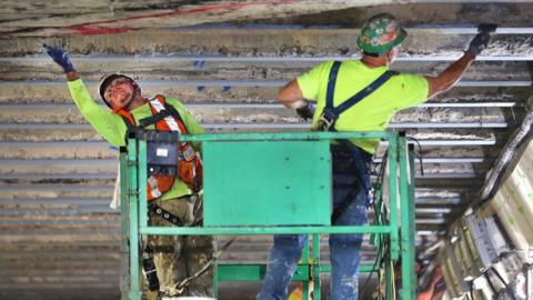 Workers on a lift do repair work to the ceiling of the Sumner Tunnel.