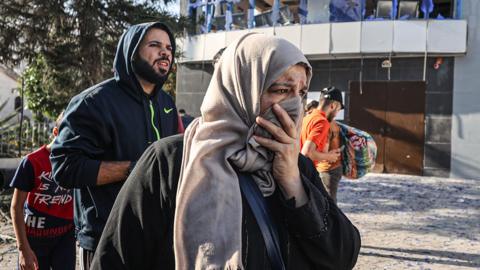 Palestinians evacuate the Al-Ahli Arabi Baptist Hospital for safer spots after it was hit in Gaza on 18 October