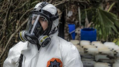 A Sinaloa state police officer works during the dismantle of one of the three clandestine laboratories producers of synthetic drug, mainly methamphetamine in El Dorado, Sinaloa state, Mexico on June 4, 2019.