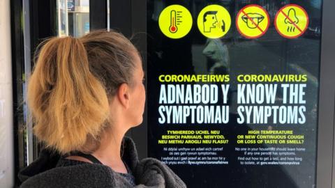 A sign in a bus shelter gives information on Coronavirus Symptoms in both Welsh and English language on May 24, 2020 in Penarth, Wales .